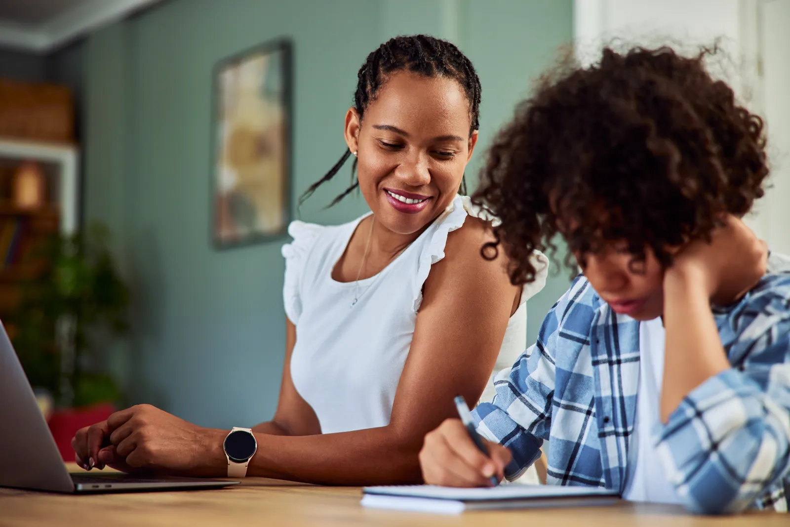 Teen completing an assignment at home with supportive adult guidance
