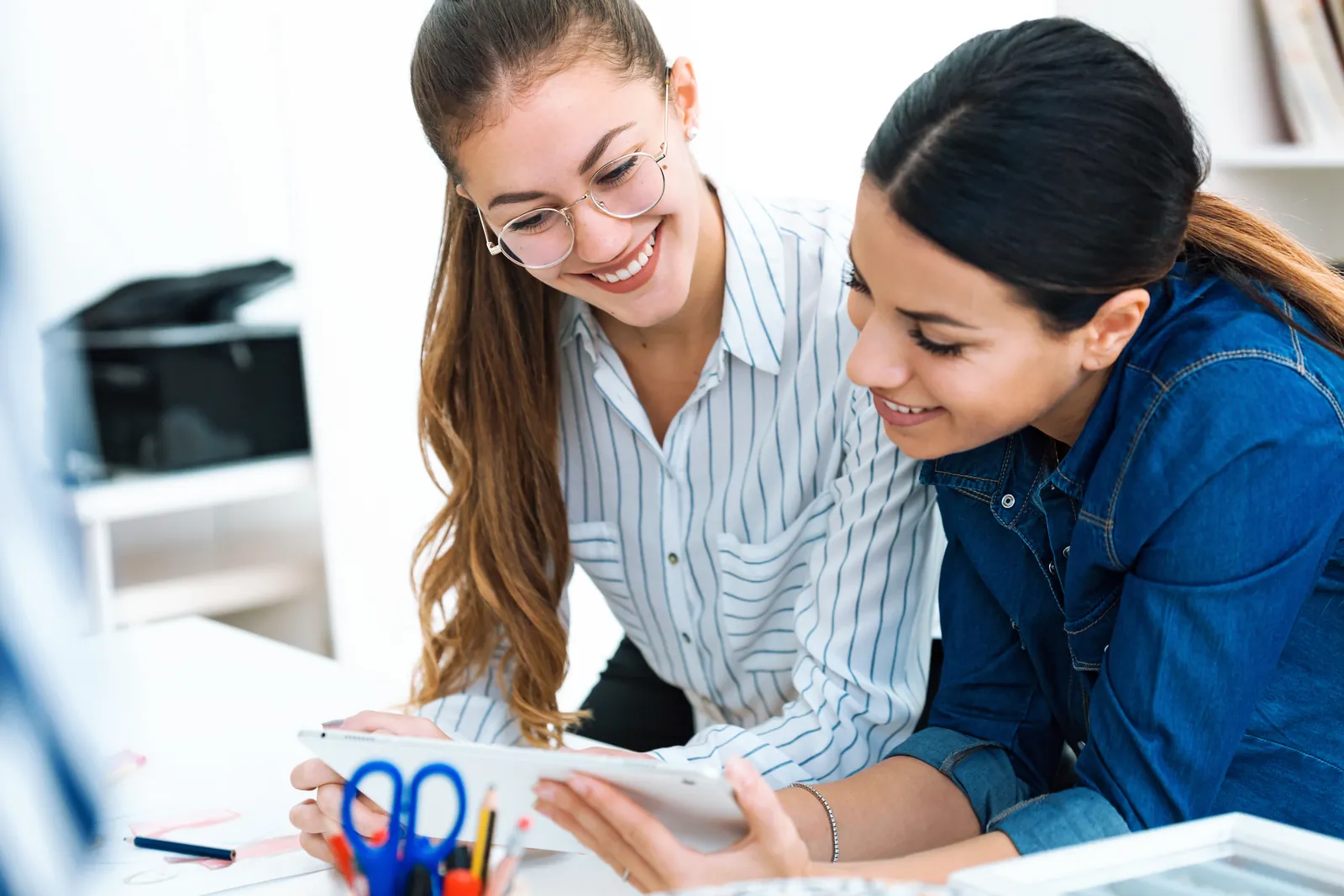 Two education professionals planning together with a digital tablet